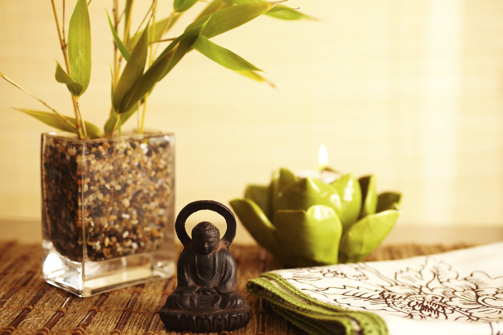 Bouddha en décoration avec un vase, une bougie et une plante dans un style zen.