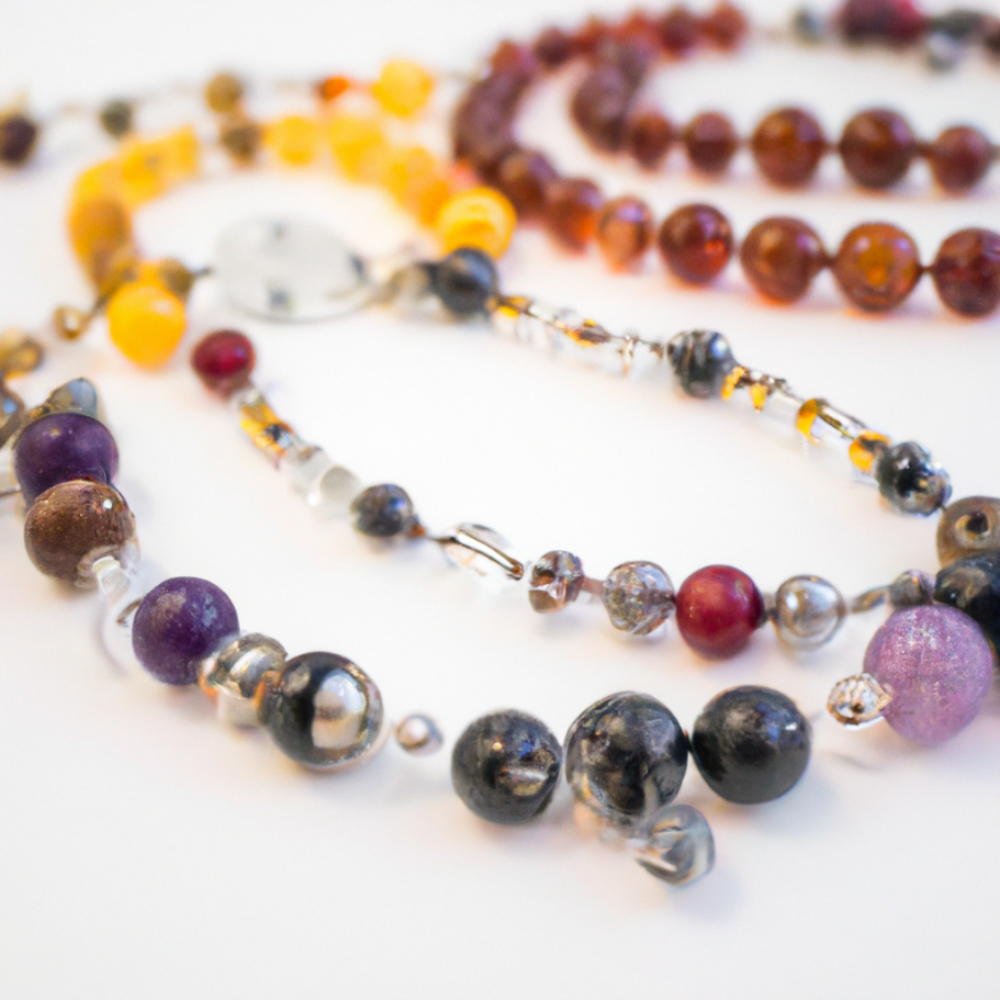 Colliers et bracelets en perles multicolores avec des pierres semi-précieuses et un fermoir.